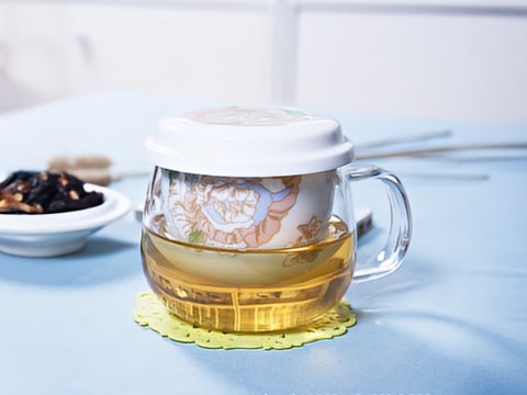 Kubek szklany z ceramicznym zaparzaczem i przykrywką.