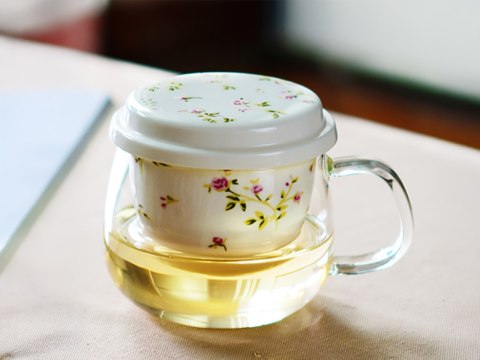 Kubek szklany z ceramicznym zaparzaczem i przykrywką.